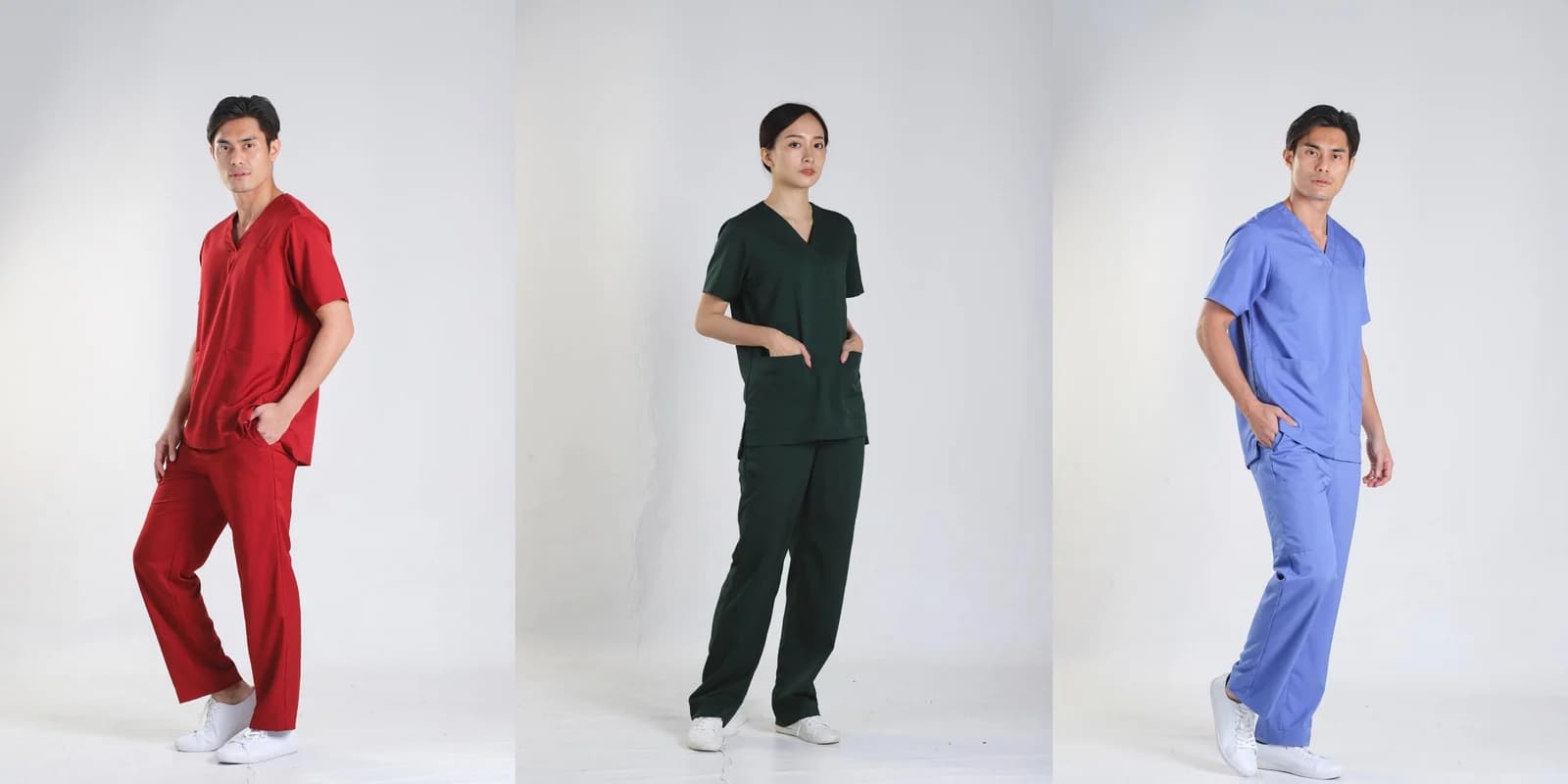 Three people wearing hospital scrubs in red, green and blue