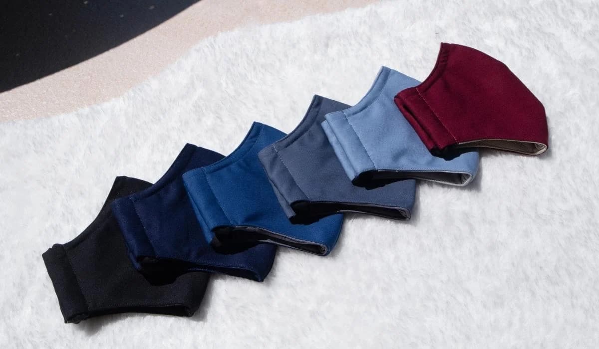 Six PEFORE. Classic masks in solid colours laid out on white fur