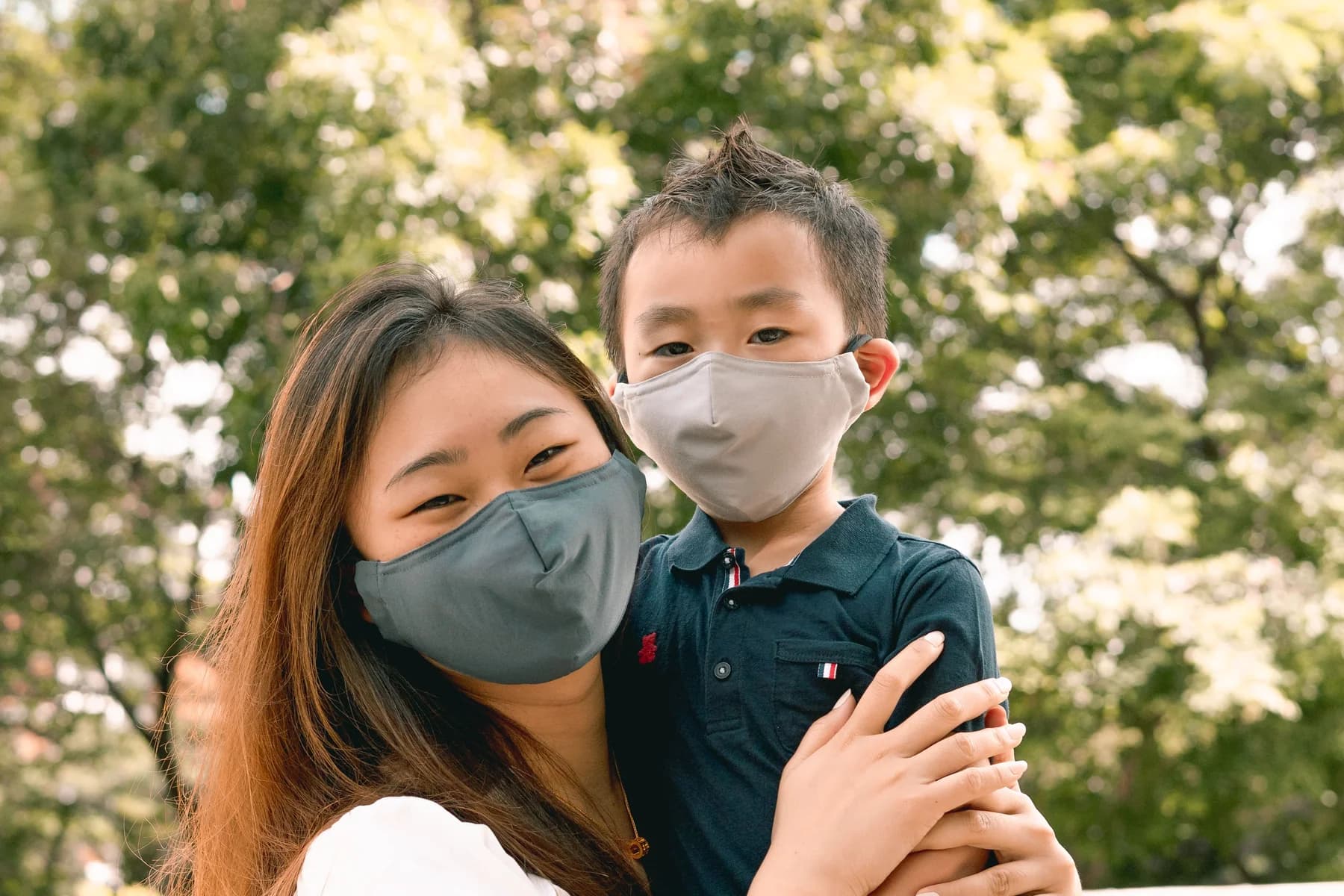 Mother and young son smiling in matching grey PEFORE. masks