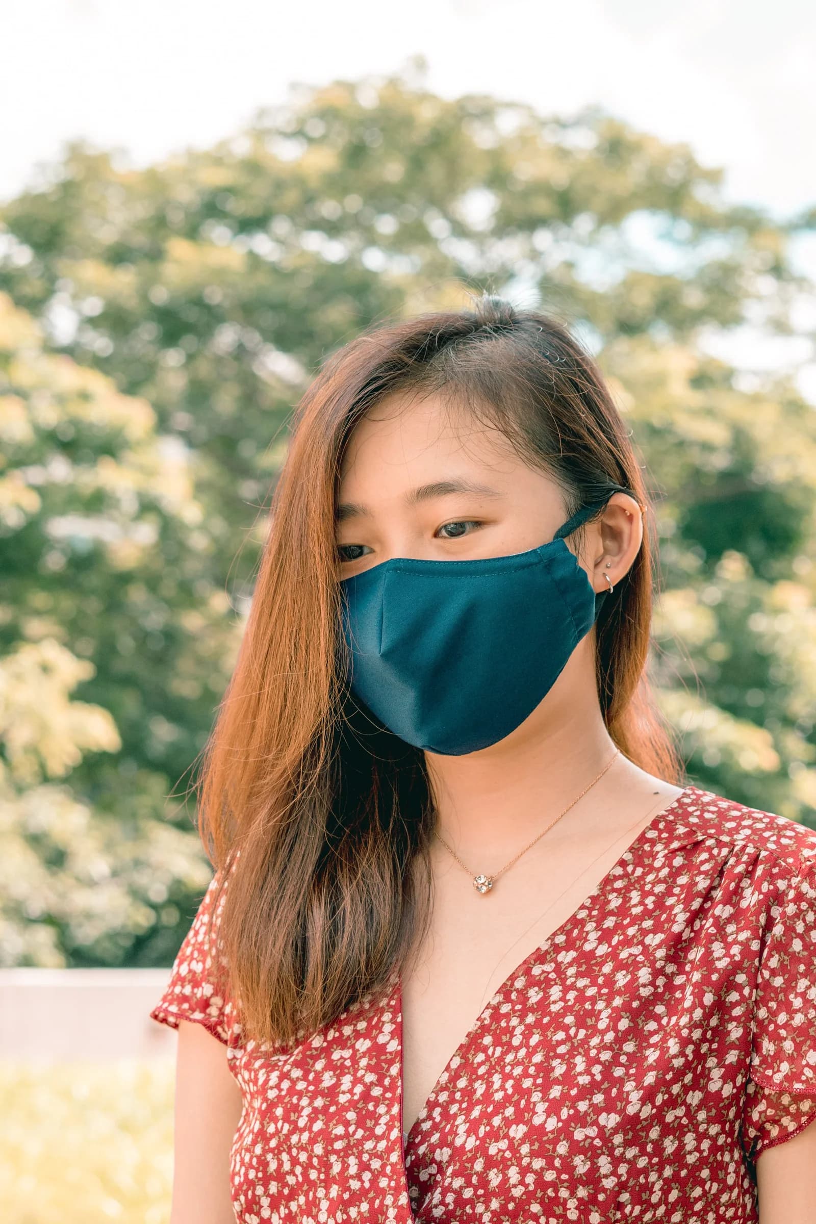 Woman outdoors wearing a teal PEFORE. Classic mask